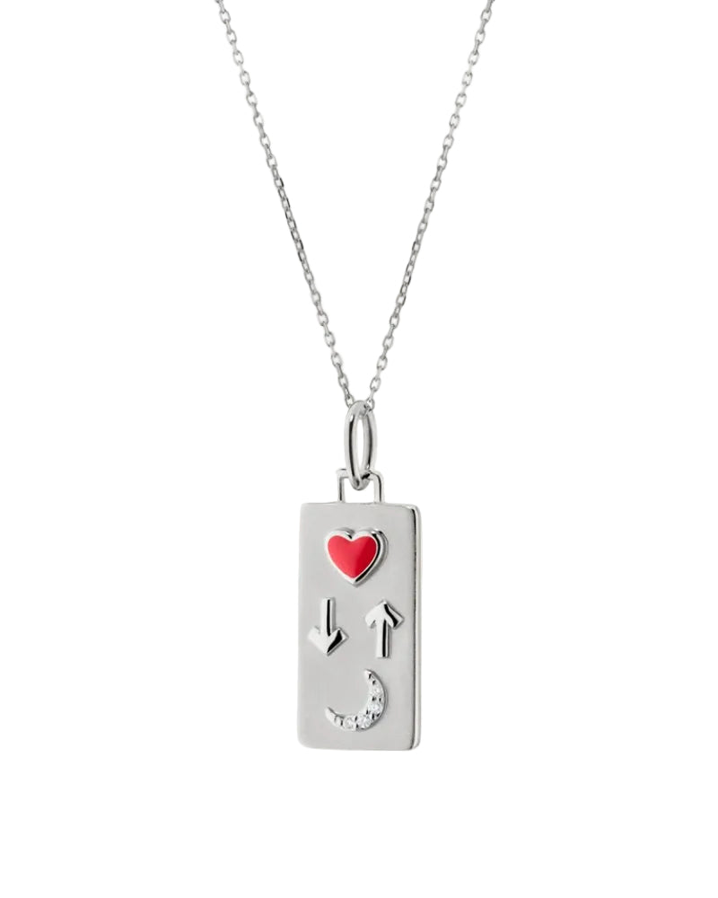A silver rectangular pendant necklace featuring a small red heart, arrow symbols, and a crescent moon, suspended from a delicate silver chain against a light cream background.