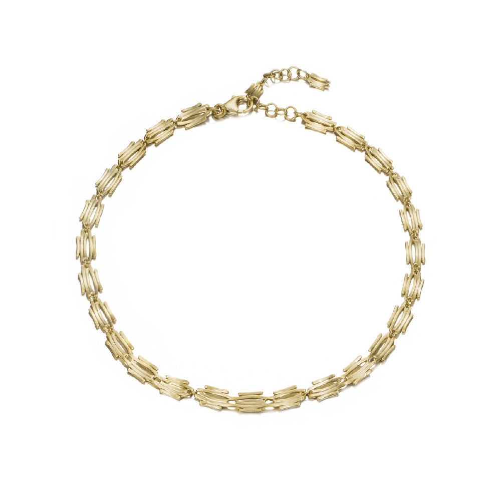 gold tone necklace on white background