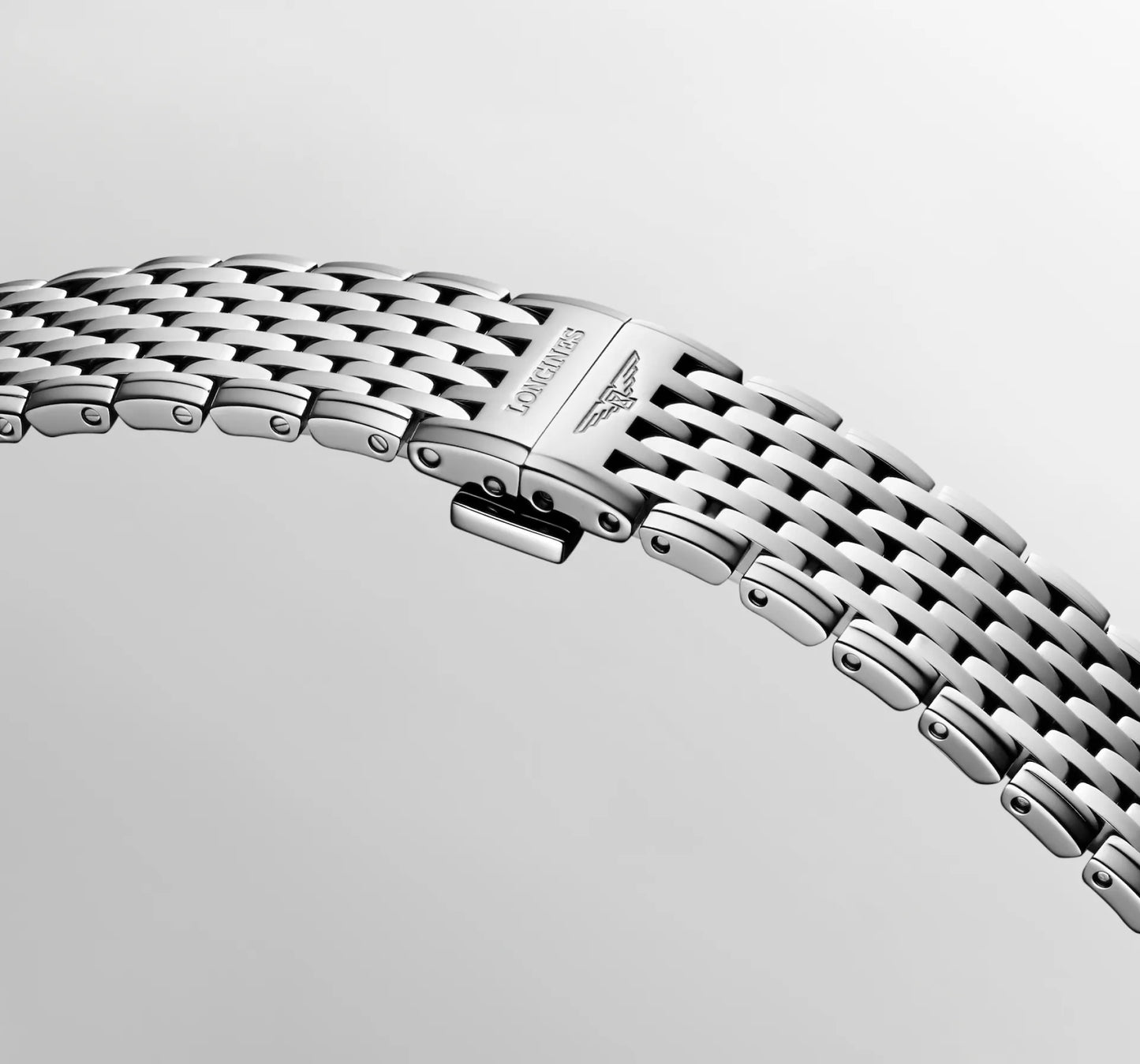 Close-up of a silver watch bracelet on a light gray background