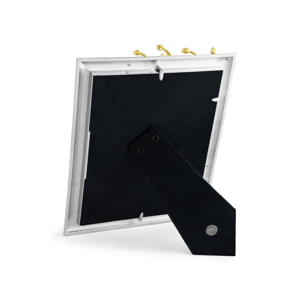 An elegant photo frame with a gold and white enamel design, featuring an orchid motif, from the Michael Aram brand.