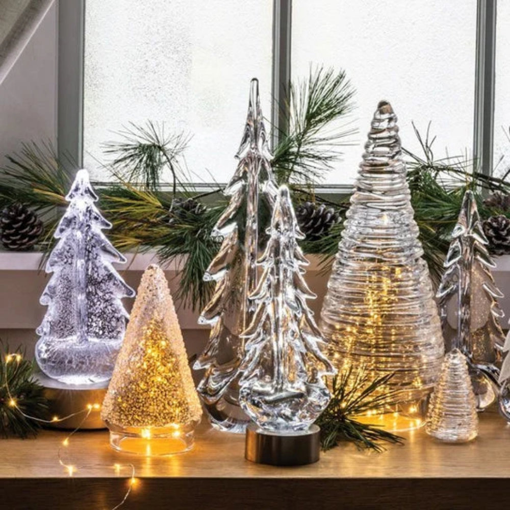 Lighted Clear glass evergreen trees on a window.