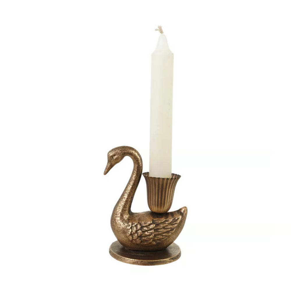A swan-shaped candle holder in an antique gold finish, holding a single white taper candle, set against a plain white background.