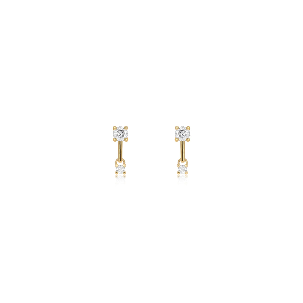 Pair of gold earrings on a light beige background