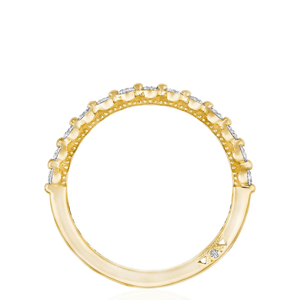 A two-prong diamond band ring with round and logo diamonds set in 18k yellow gold.