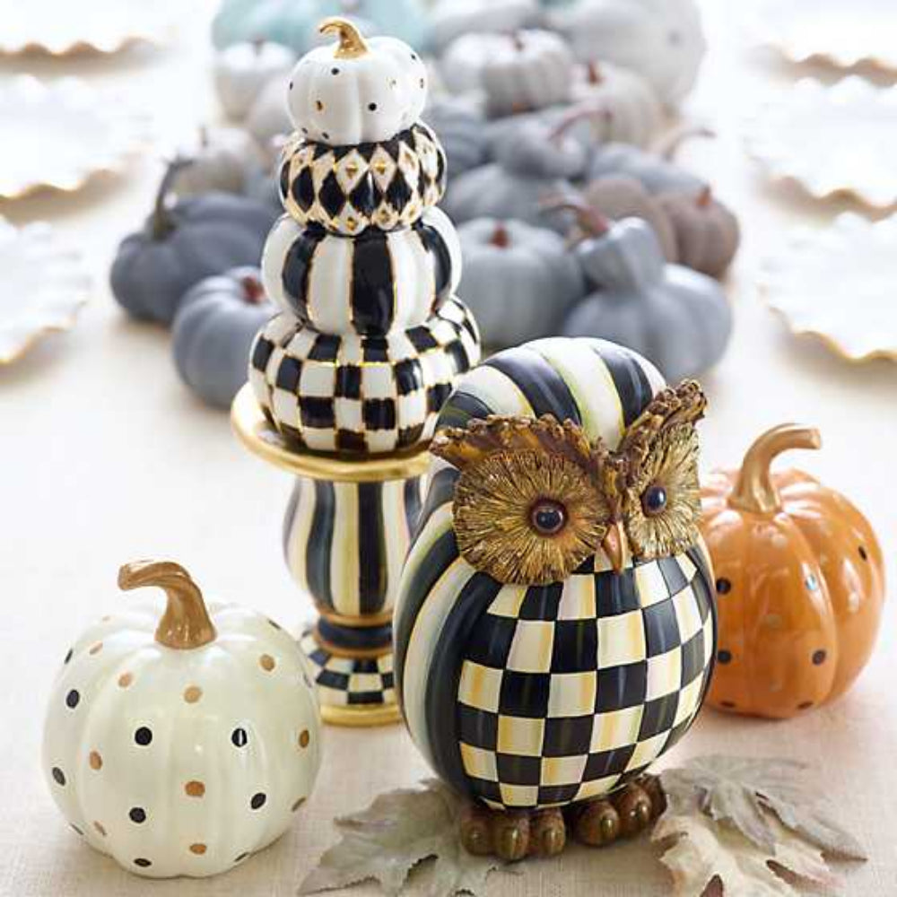Decorative owl and pumpkin figurines with checkered pattern on a light tan background