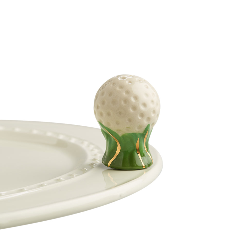 Golf ball-shaped object with green base on a white plate