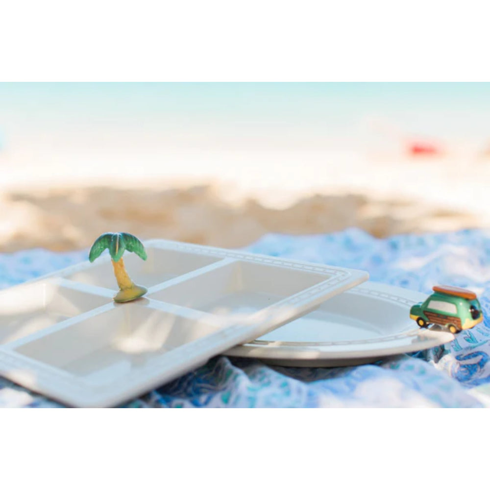 Small minis on white plates on beach towel.
