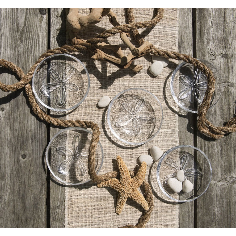Multiple sand dollar bowls with ropes and starfishes around its displays.