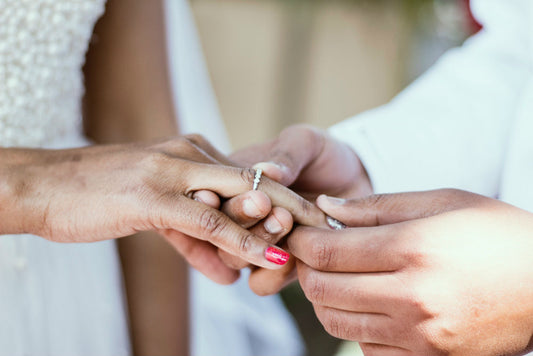 man putting ring on woman hand