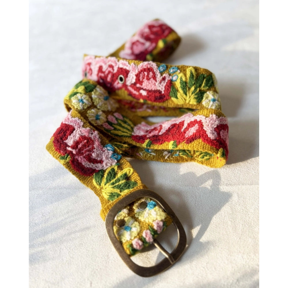 Floral patterned belt with a decorative buckle on a white background