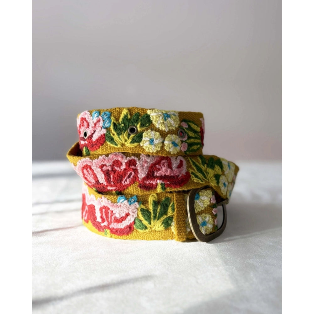 Floral patterned belt on a white surface with a light gray background