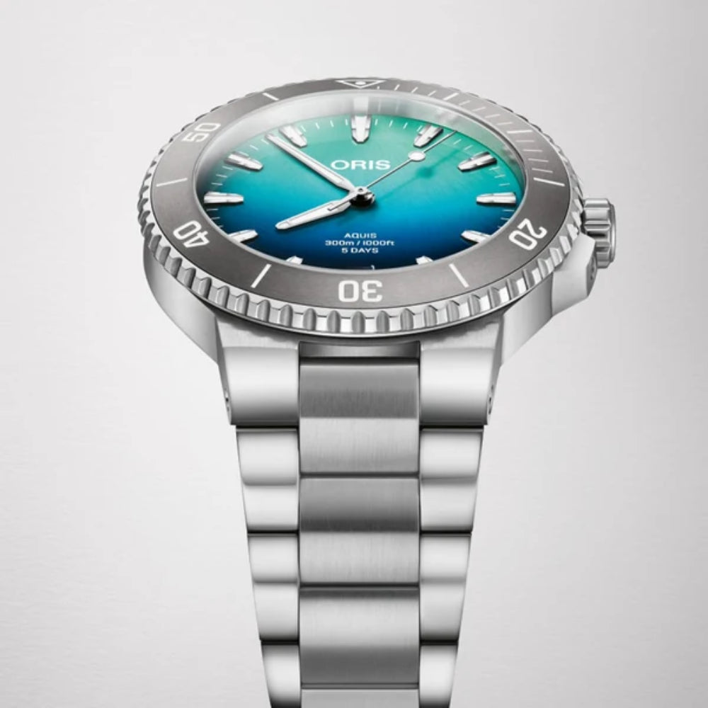 Silver Oris watch with a blue gradient dial on a light gray background