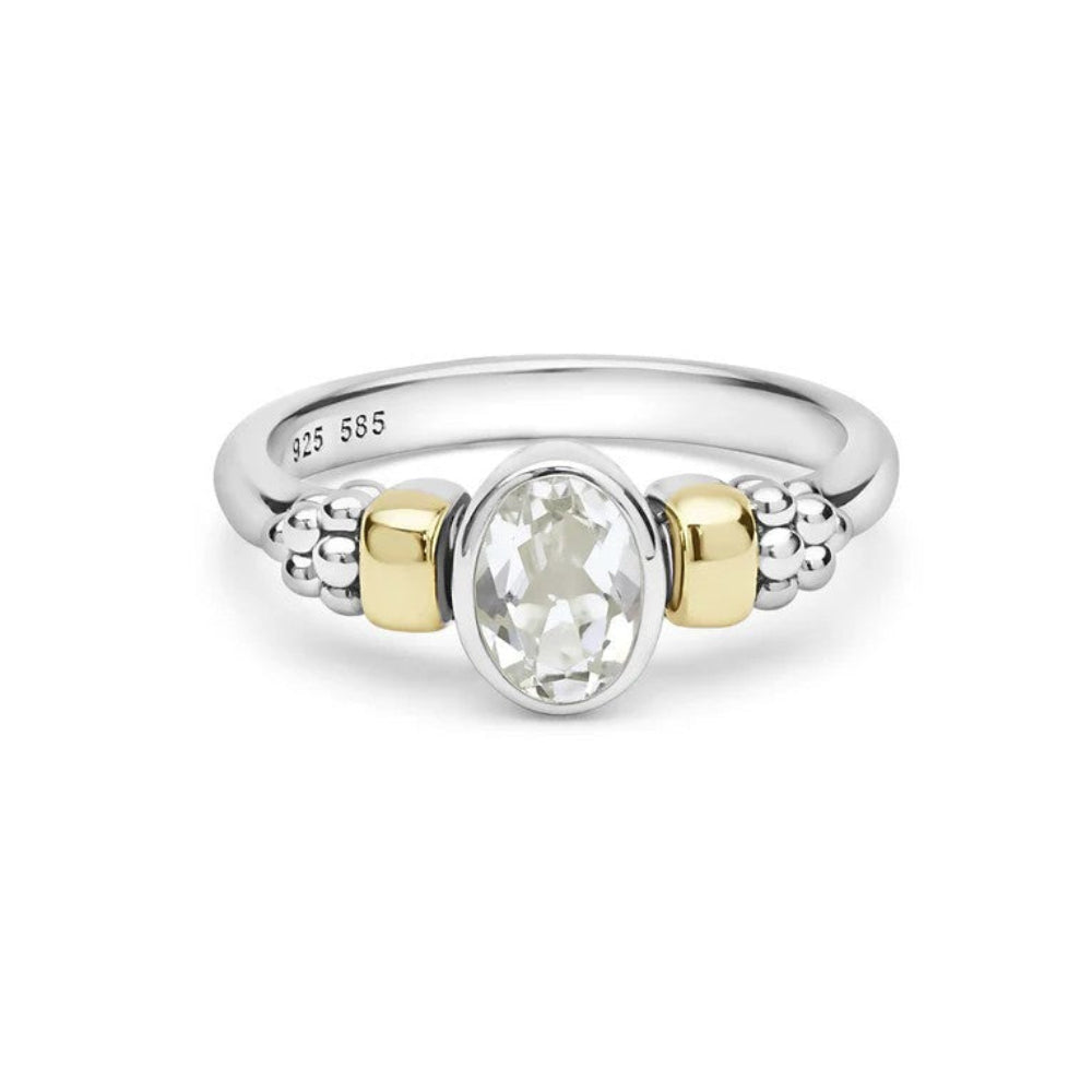 A two-tone silver and yellow gold ring featuring a central oval White Topaz , with textured bead details on either side of the band. 