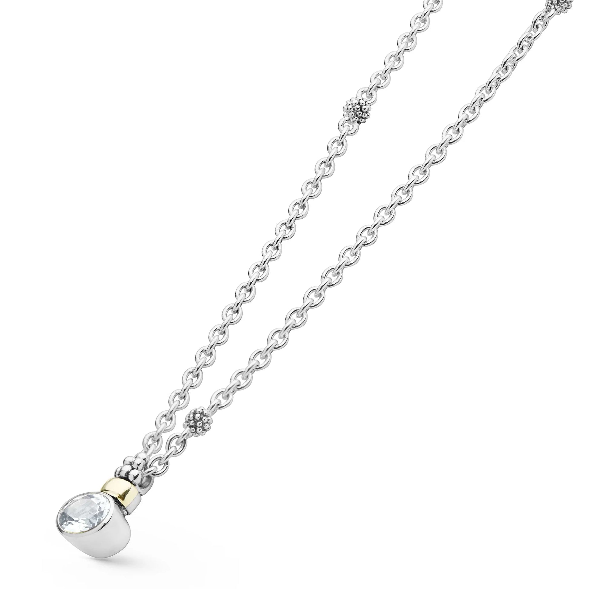 A silver chain necklace with a small clear faceted gemstone pendant in a silver bezel, accented by a tiny gold spacer ring, shown on a plain white background.
