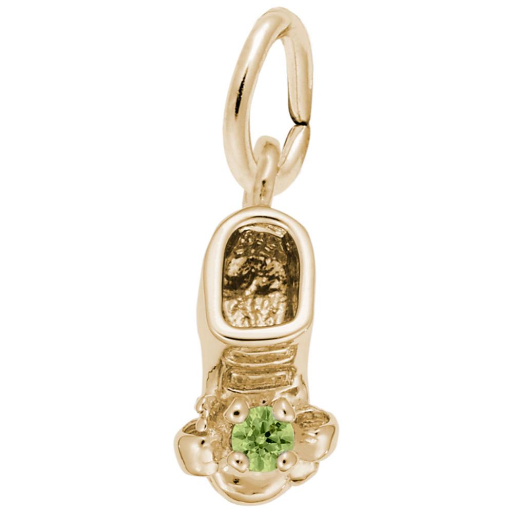 Gold baby-bootie charm with a green gemstone on a white background