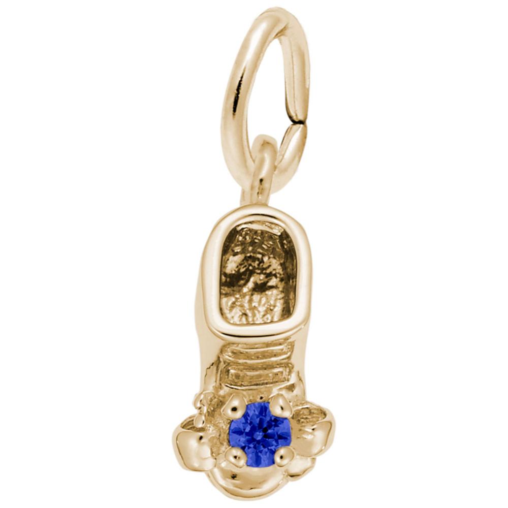Gold baby-bootie charm with a blue gemstone on a white background