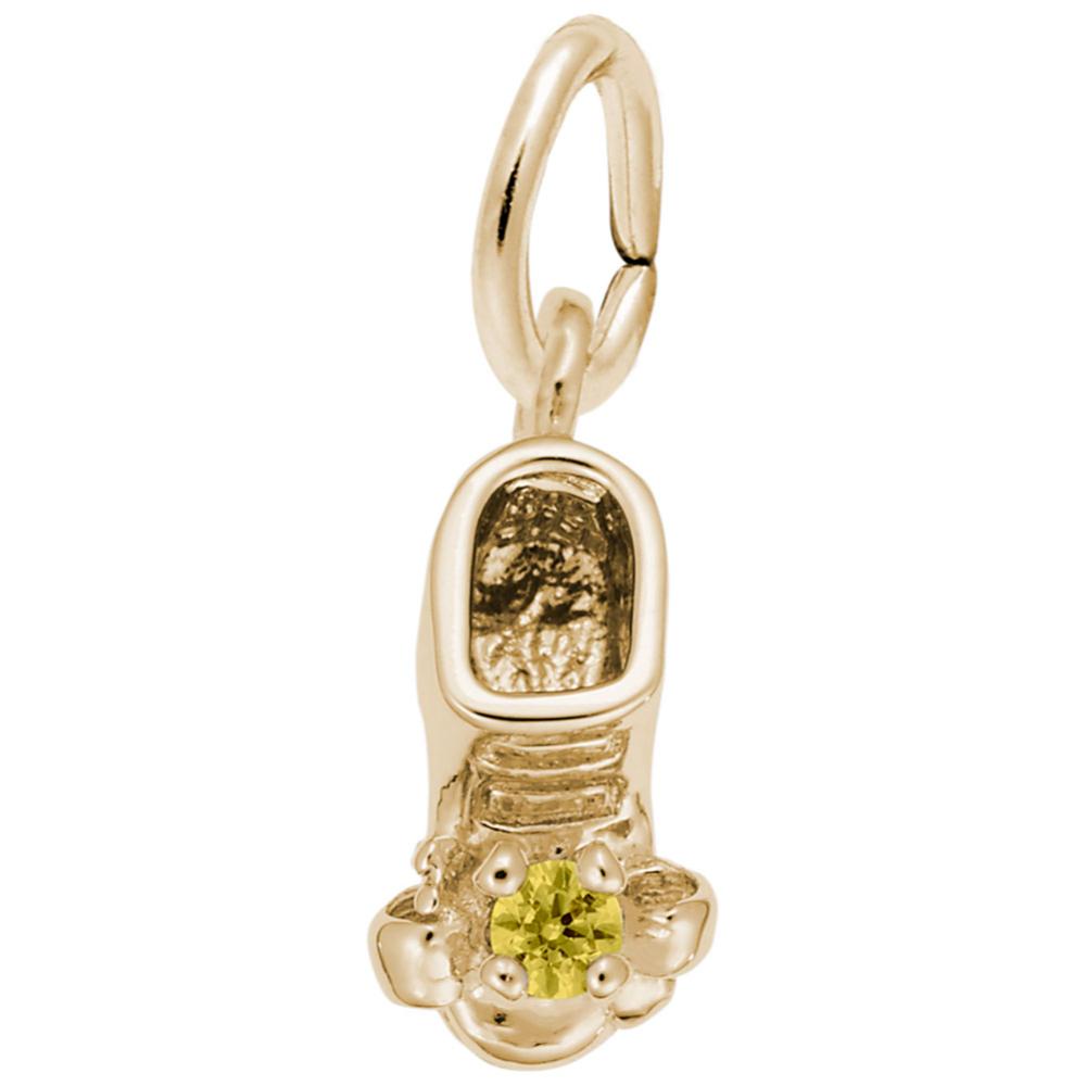 Gold baby-bootie charm with a green gemstone on a white background