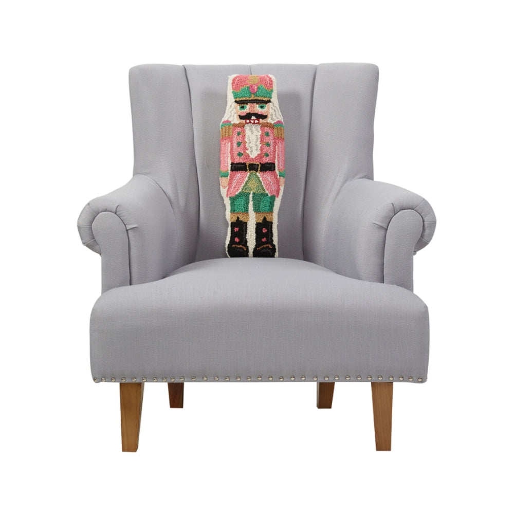 Gray armchair with a colorful knitted nutcracker decoration on a white background