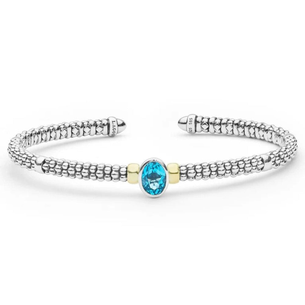 A Sterling silver textured cuff beaded bracelet with a central oval diamond Blue Topaz accented by two small gold-toned beads