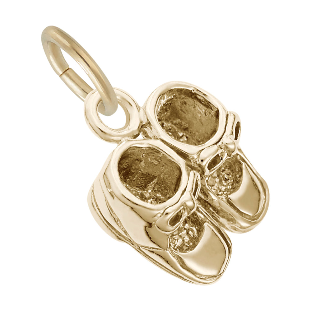 Gold baby shoes charm on a white background top view