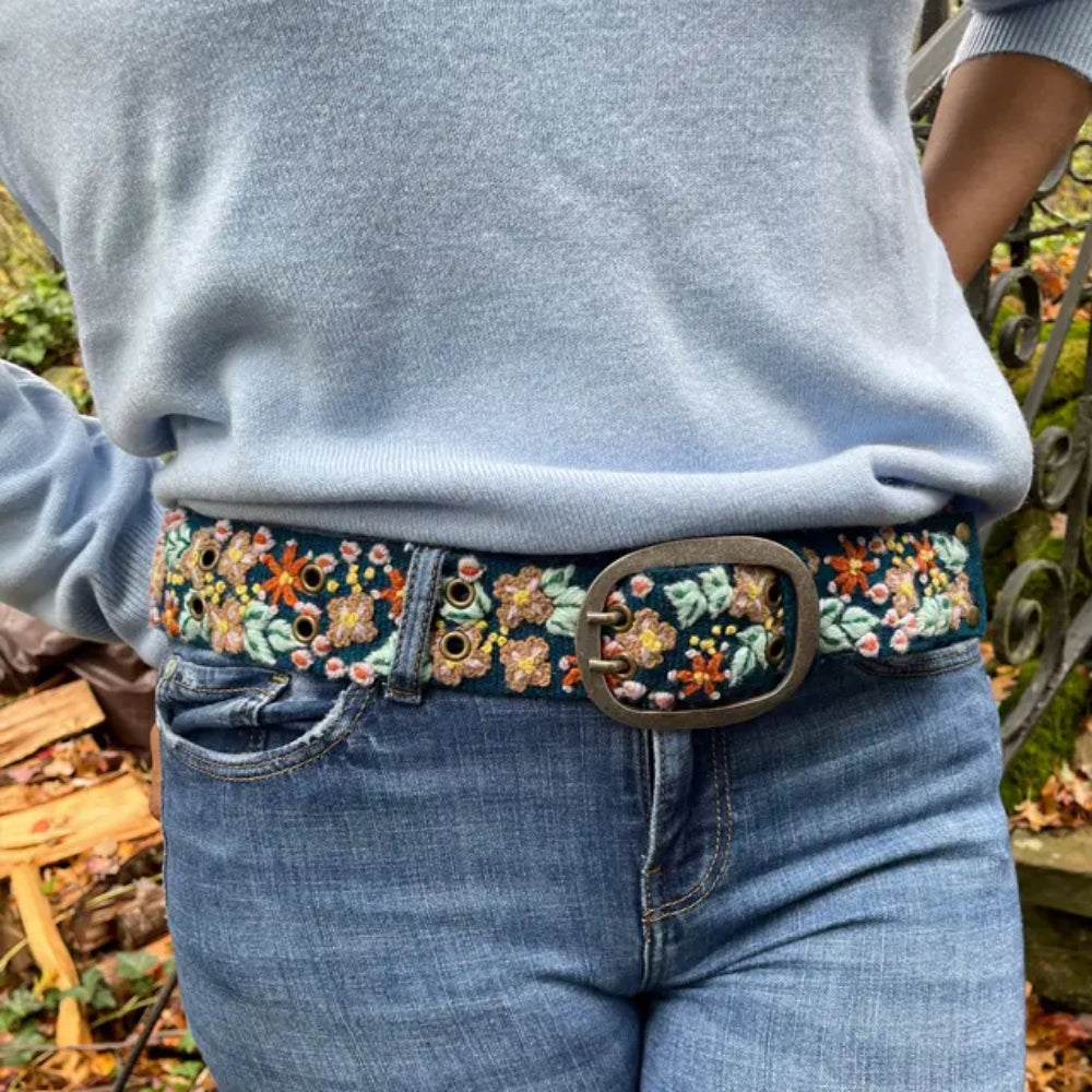 Person wearing Floral patterned wool belt in jeans outdoors
