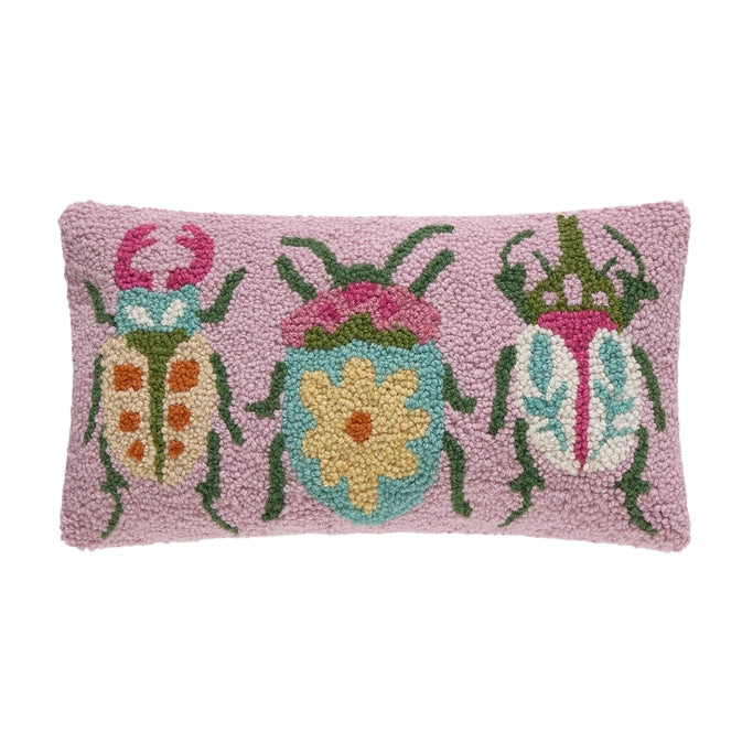 Decorative pillow with floral beetle design on a pink background