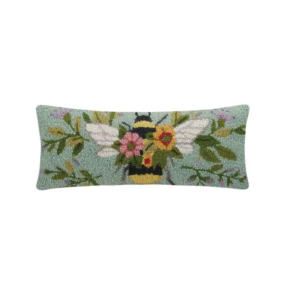 A rectangular accent pillow with a floral pattern and a bee design in the center, predominantly in shades of green, blue, and yellow.