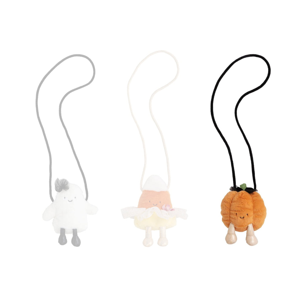 Pumpkin themed halloween plush purse against a white background.