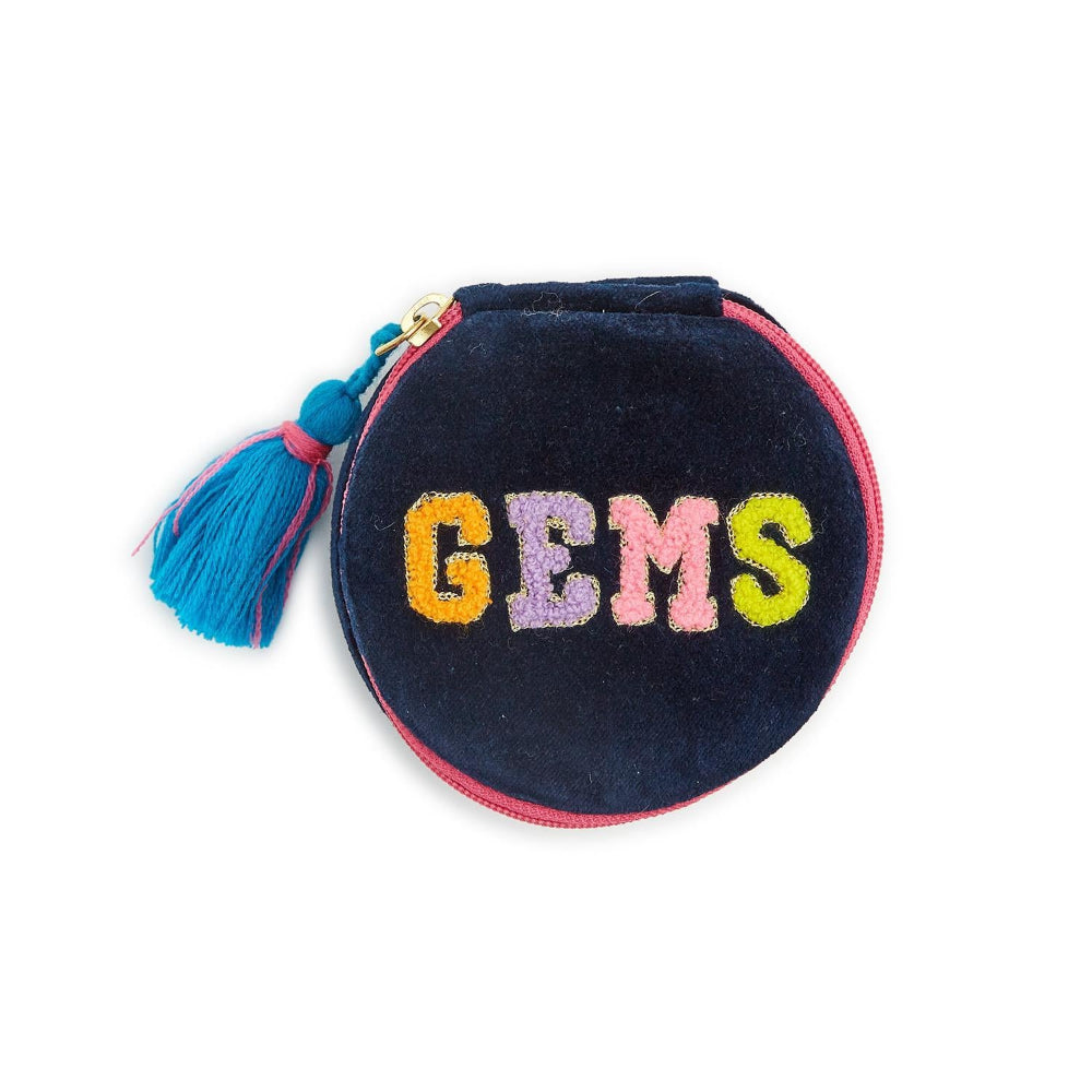 A round navy blue velvet coin purse with a tassel zipper pull, featuring the word 'GEMS' embroidered in colorful pastel letters across the front.