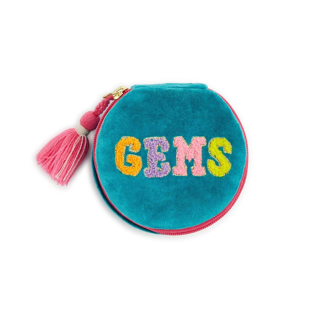 A round teal velvet coin purse with a pink zipper and a pink tassel. The word 'GEMS' is embroidered across the front in colorful glittery letters (yellow, purple, pink, and green).