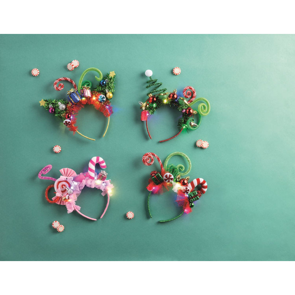 Four colorful headbands with LED lights on a green background.