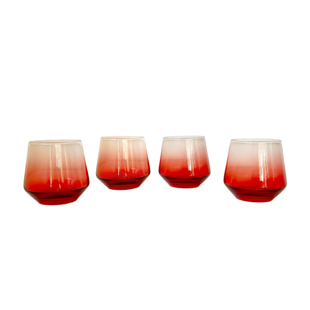 Four stemless cocktail glasses with a red-to-clear ombre gradient, arranged in a row against a plain white background.
