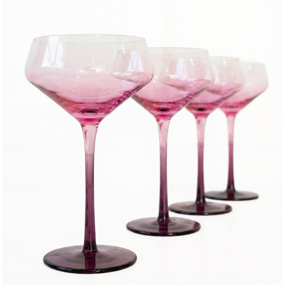 Four stemmed cocktail glasses with a pink-to-purple gradient, arranged in a row on a white background.