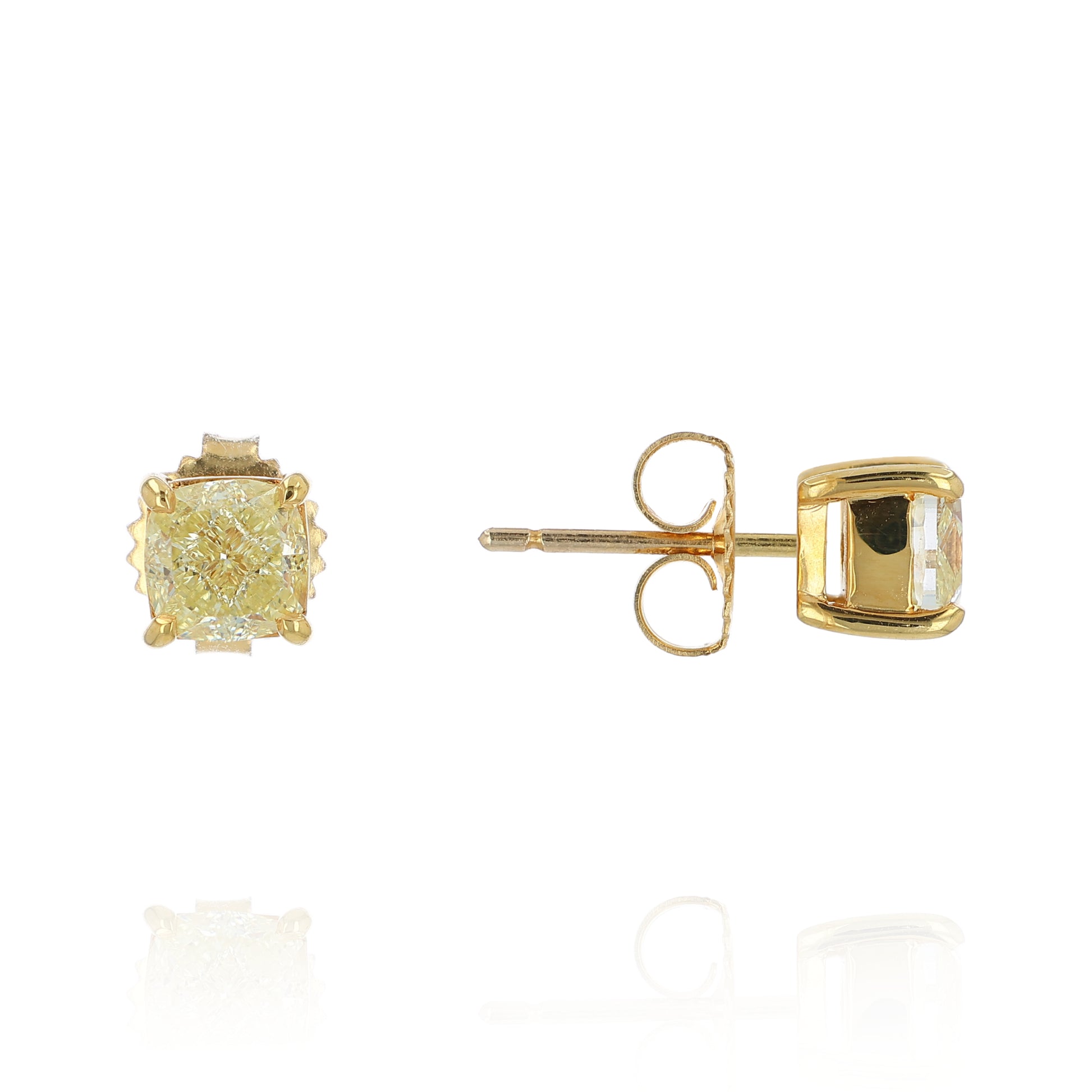 A pair of yellow gold stud earrings with cushion-cut fancy yellow diamonds, shown from the front and side on a white background with a soft reflection.
