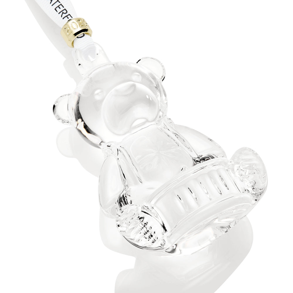 Clear glass bear-shaped ornament with a white straw on a white background