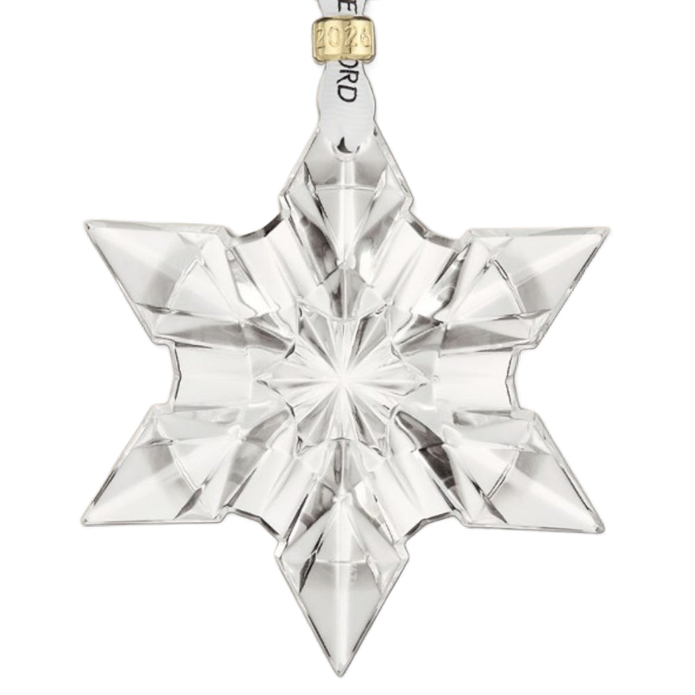 Clear star-shaped crystal ornament with gold accent around ribbon on a white background