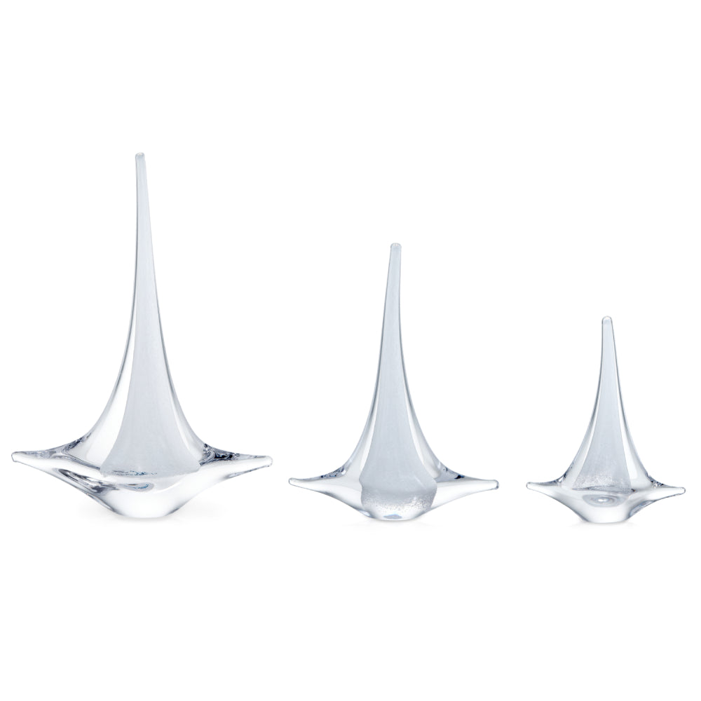 Three clear glass teardrop sailboats on a white background