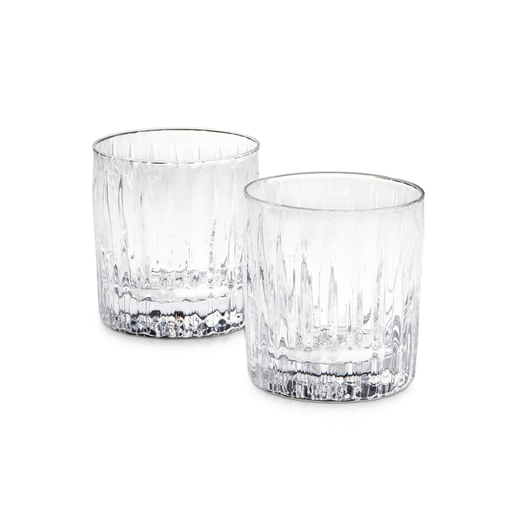 Two clear double old-fashioned glasses with textured bottoms on a white background