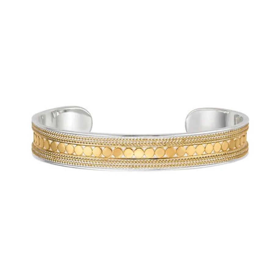 A two-tone cuff bracelet featuring a textured gold center band with circular dot patterns and fine milgrain detailing, set on a polished silver-tone base, shown against a plain white background.