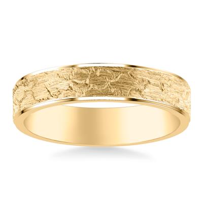 Gold ring with textured band on a white background