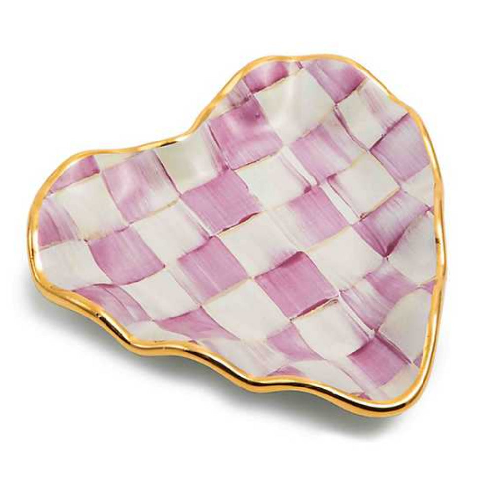 A hand-painted pink checkered plate with gold trim on the edges and a fluted design, shaped like a heart.