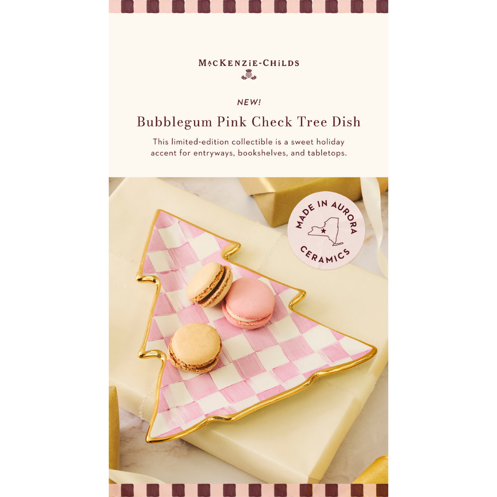 McKenzie-Childs Bubblegum Pink Check Tree Dish, a limited-edition collectible ceramic tree-shaped plate with a pink and white checkered pattern and gold trim, shown on wrapped gifts with macarons.