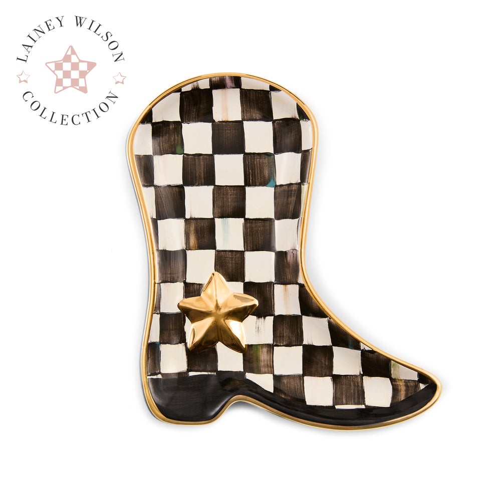 A cowboy boot-shaped decorative dish or tray from the Lainey Wilson Collection, featuring a black and white checkered pattern, a gold star accent, and a gold rim on a white background.