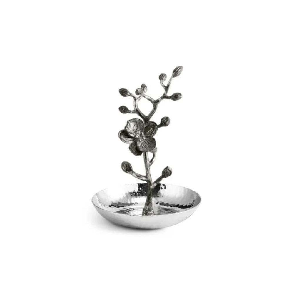 A silver-toned metal orchid branch figurine with a textured hammered finish, featuring a single flower and buds rising above a shallow matching dish, set against a plain white background.