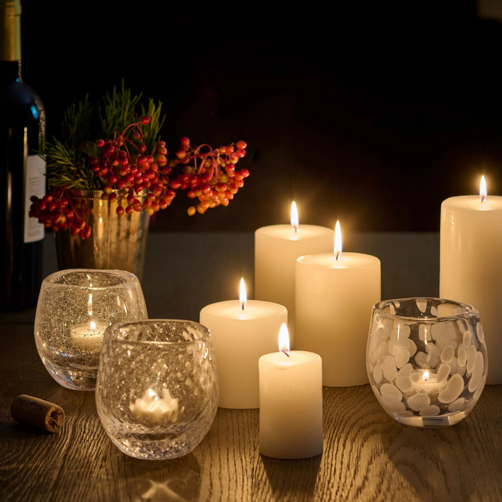 Candles and glass holders on a wooden table with a dark background