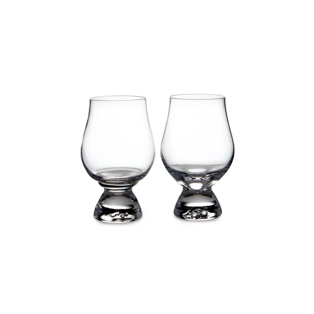 Two clear glass tasting glasses on a white backround. 