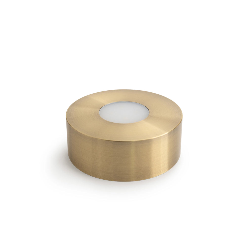 A small brass cylindrical light fixture on a white background.