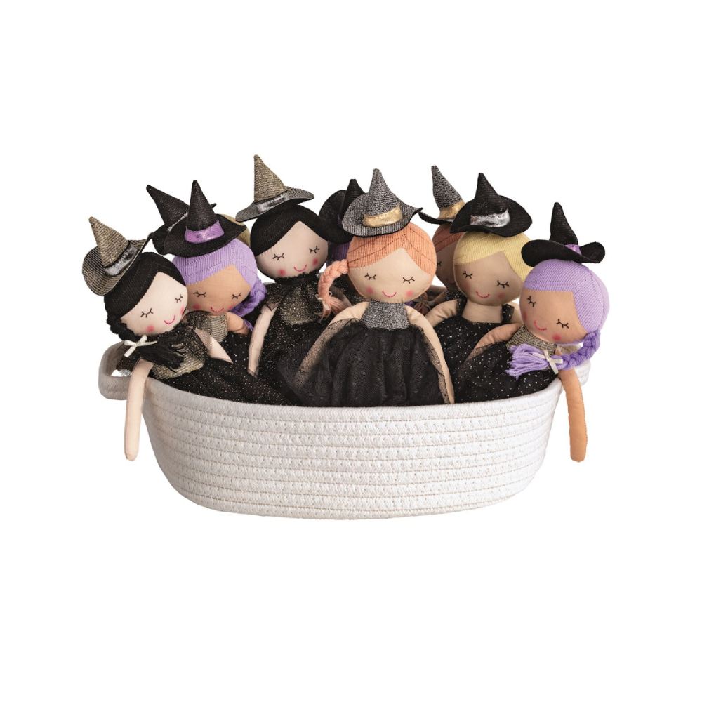 Witch-themed dolls in a woven white basket on a white background.