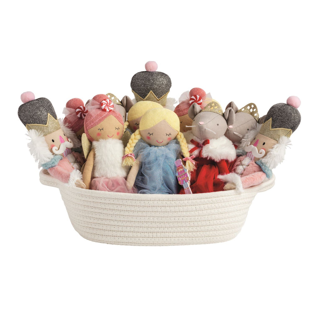 Basket filled with small holiday nutcracker ballet themed dolls a on a white background.