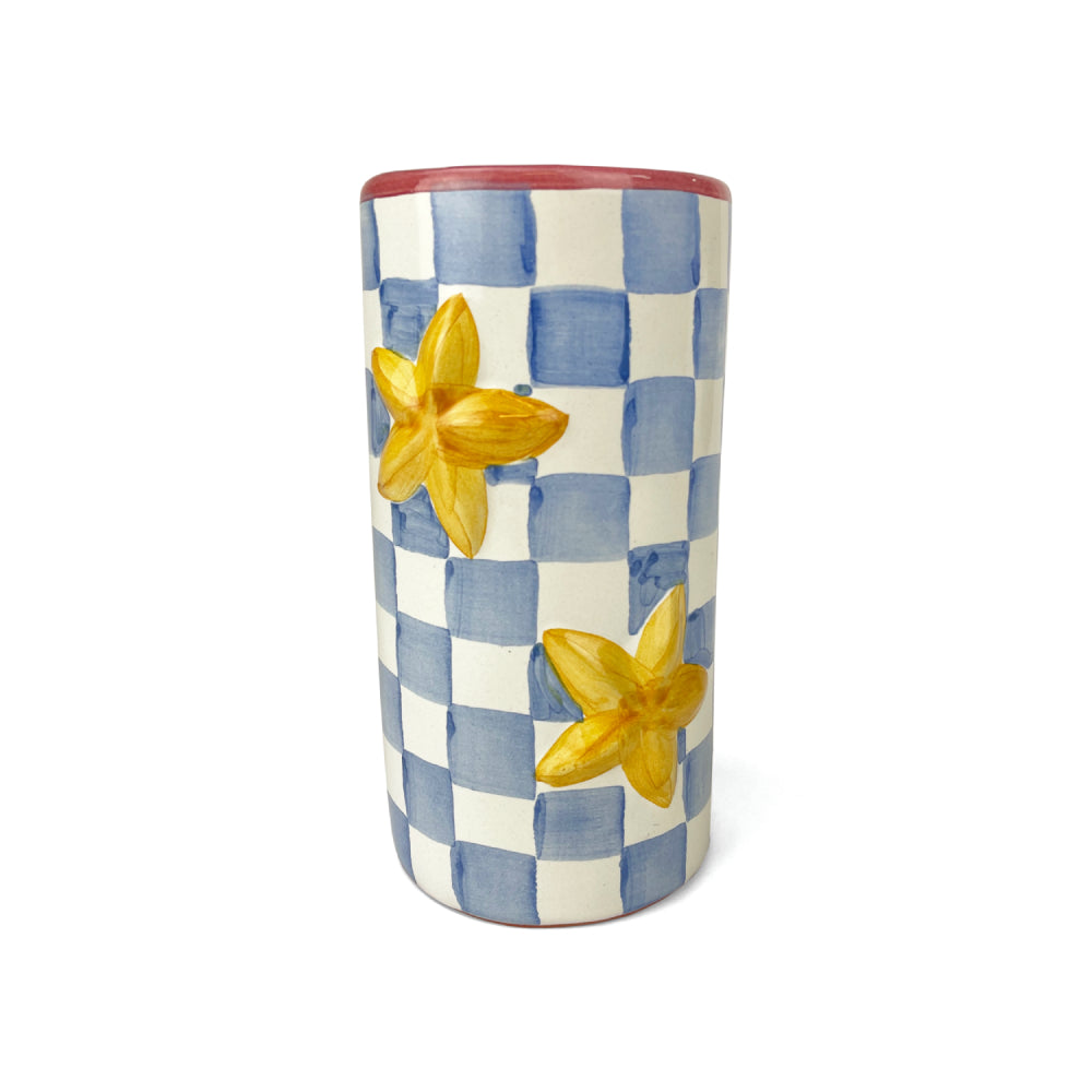 MacKenzie Childs blue and white checkered ceramic cylindrical vase with a red rim and yellow star accents on a white background